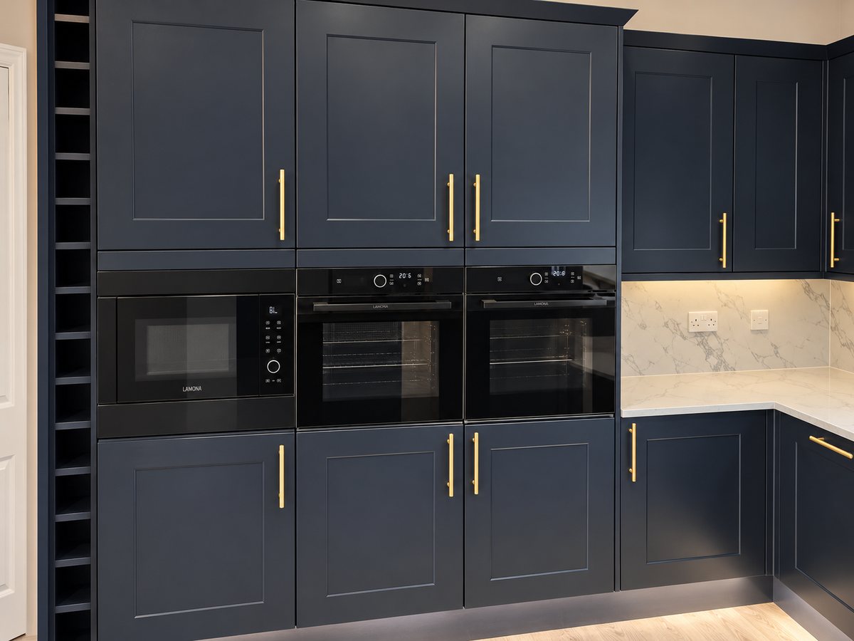 Tall cabinetry, ovens and aligned brass handles